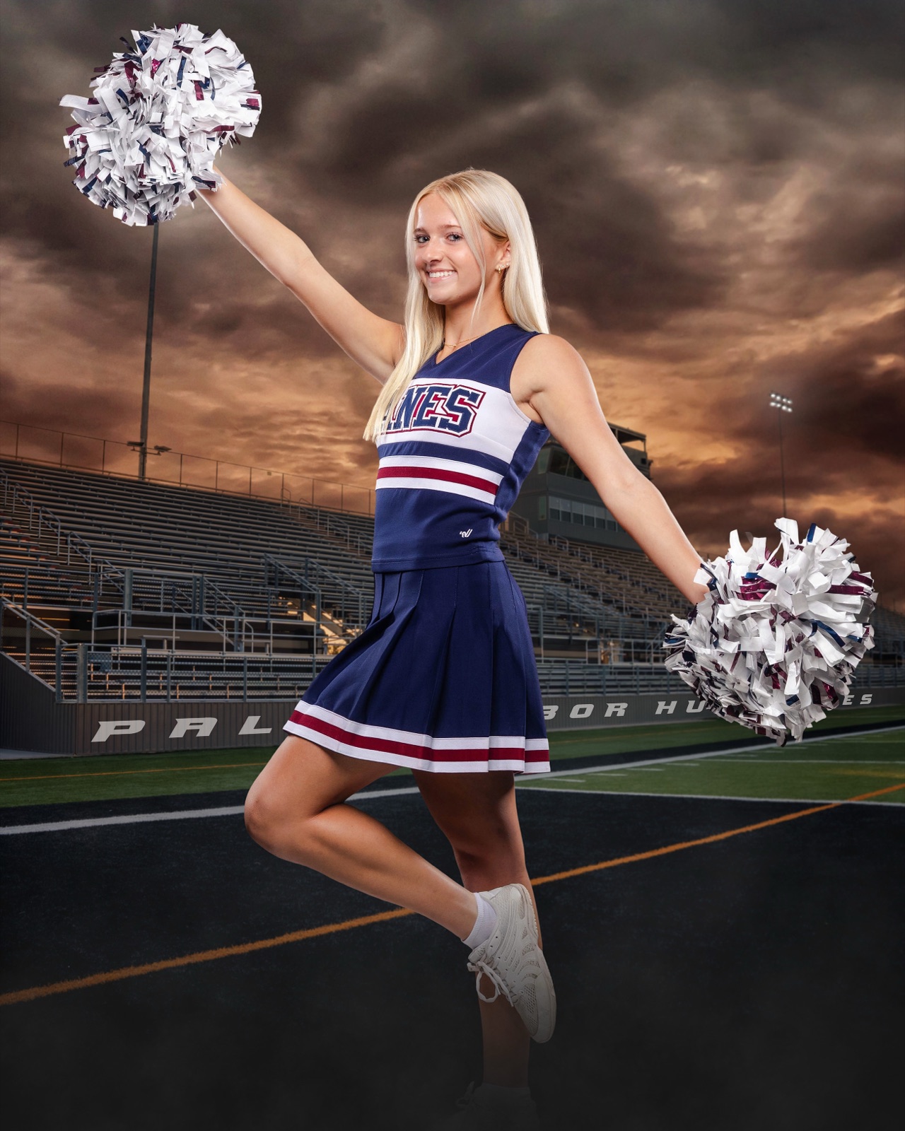 Aubrey Haugh in Palm Harbor University High School cheer uniform with poms at the football stadium