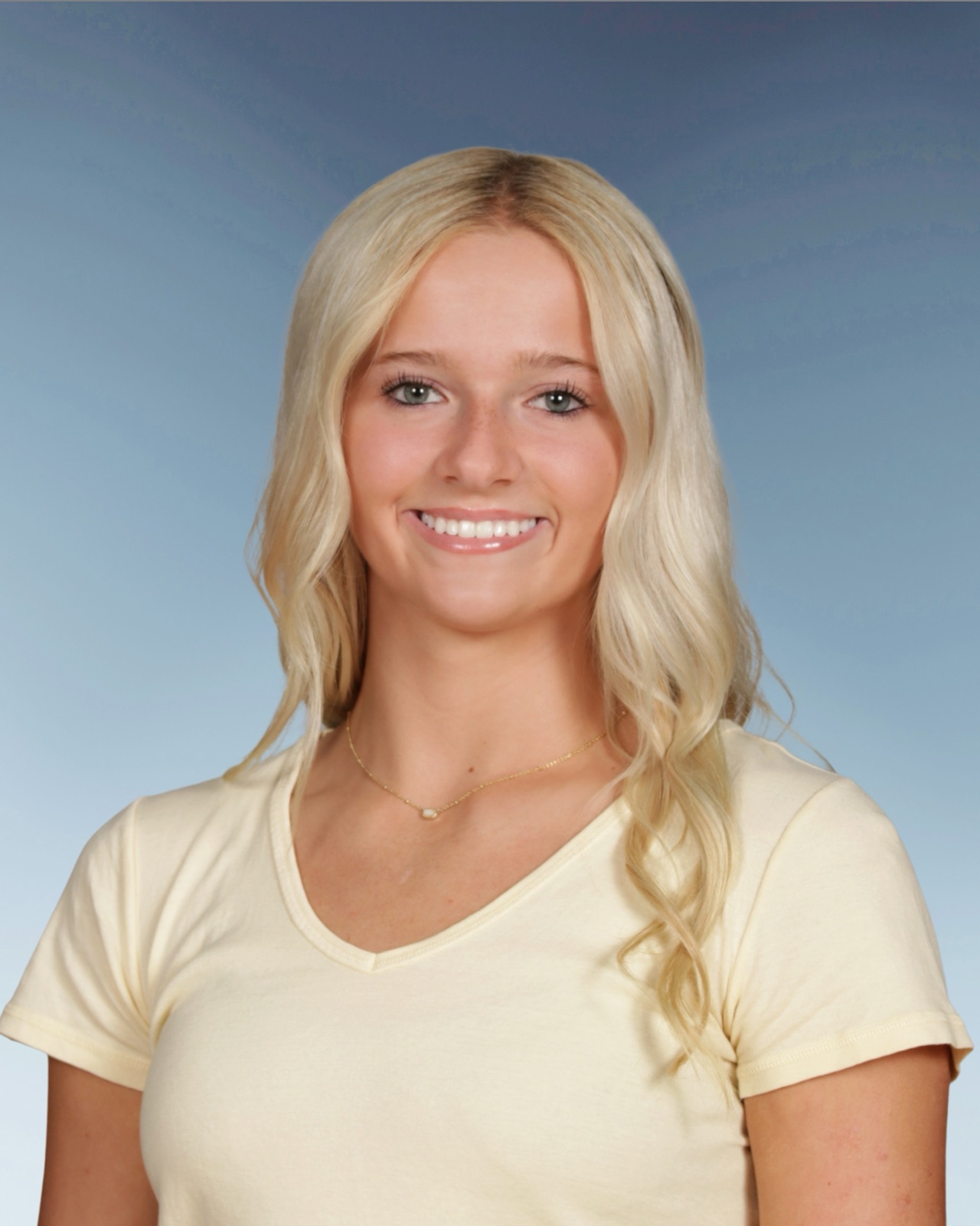 Headshot of Aubrey Haugh smiling against a blue-gray backdrop